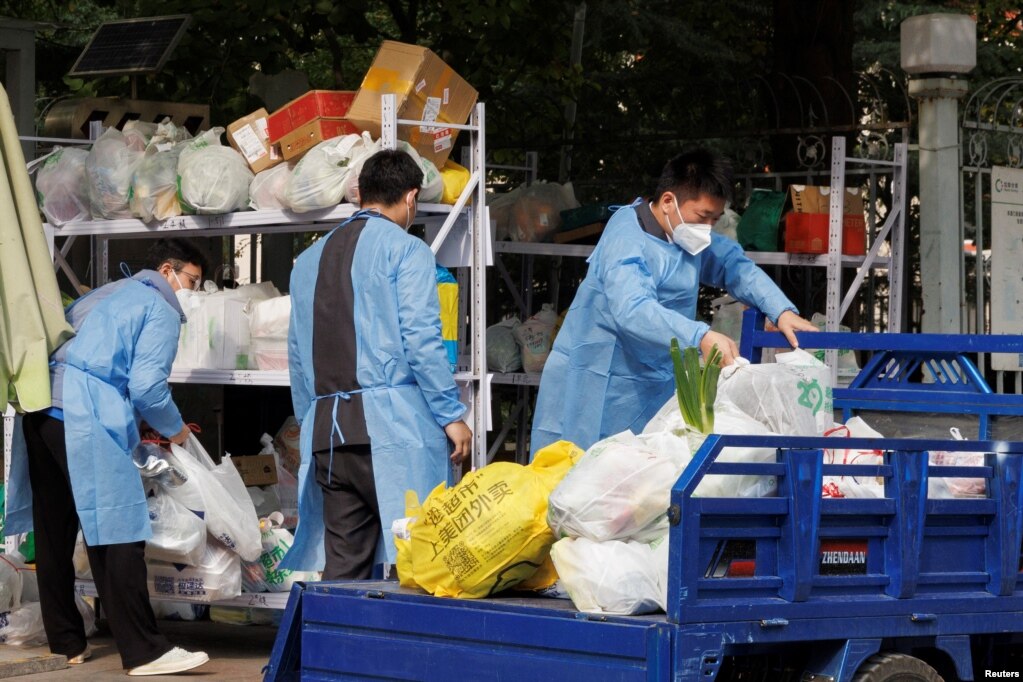北京一居民区因疫情被封后保安们卸下小区居民购买的食品袋。（2022年10月20日）(photo:VOA)