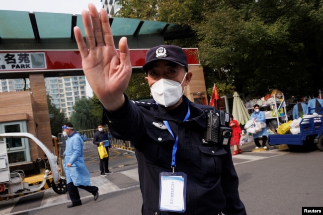 北京一居民区因疫情被封后保安禁止记者走近。（2022年10月20日）