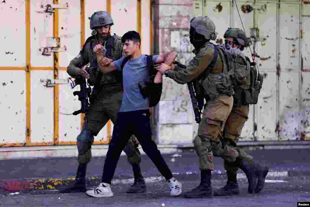 Israeli troops detain a man during a Palestinian protest over the killing of Palestinian gunmen in an Israeli raid, in Hebron in the Israeli-occupied West Bank.