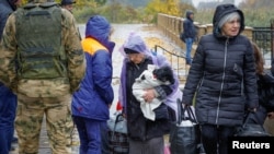 俄罗斯军队控制的乌克兰重镇赫尔松大战在即，大量平民纷纷逃离。图为赫尔松地区的奥列什基城的逃难平民。（2022年10月23日）
