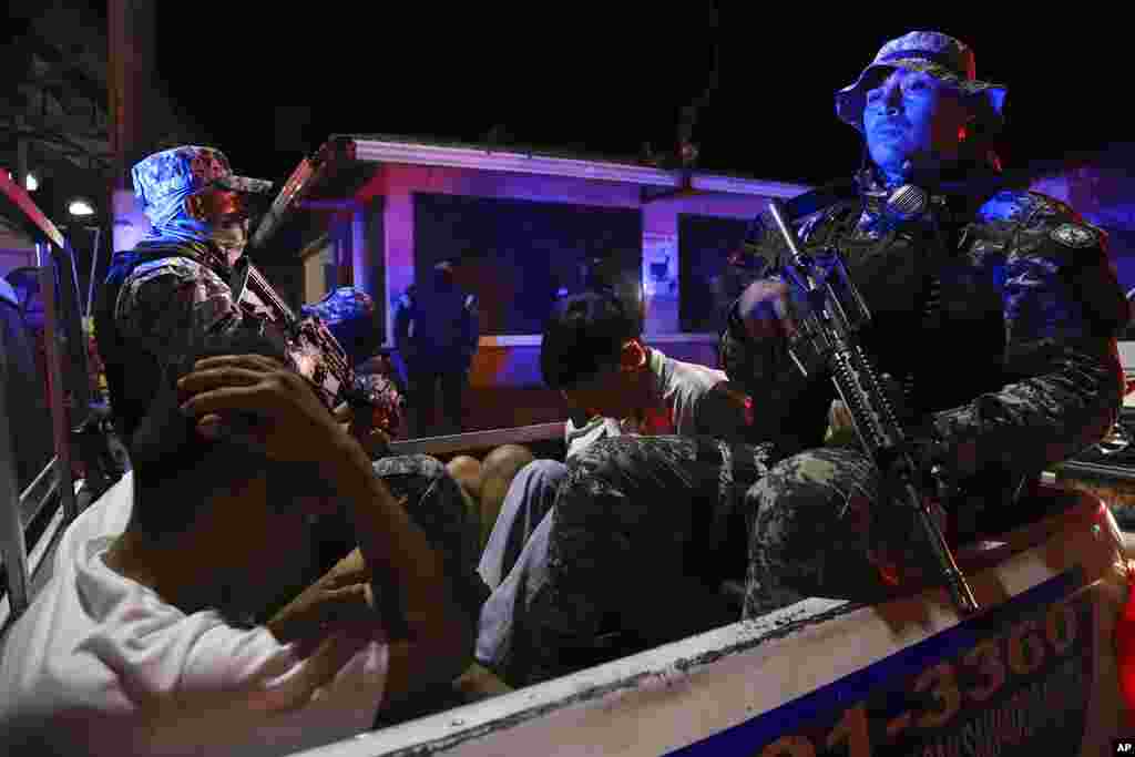 Special Forces from the National Civil Police transport people they arrested for alleged, possible links to gangs in Comasagua, El Salvador.