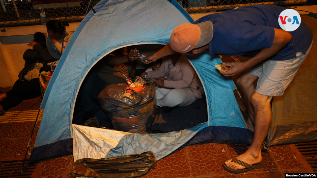 Algunos venezolanos se apoyan entre sí para comer por la noche y entretenerse. Foto Houston Castillo, VOA