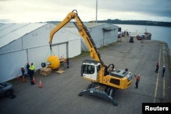 A powerfulness  shovel lifts a buoy called to assistance   debar  vessel  collisions with whales astatine  the 'Corcovado' gulf country  successful  the seashore  of Chiloe, Chile, October 10, 2022. (Fundacion MERI/Handout)