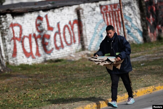 A garbage recycler, carries cardboard meant to be recycled, amidst a reduction in waste generated as a result of a change in consumer buying patterns following inflation, as the economic crisis grips, in Lomas de Zamora, in the outskirts of Buenos Aires, Argentina July 8, 2022. (REUTERS/Agustin Marcarian)