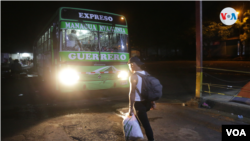 Un nicaragüense aborda un autobús de madrugada con rumbo a la frontera de Honduras para seguir su tránsito a EEUU. Foto VOA