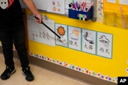 n Suzy Tom's first grade class a student points at pictures and characters on a wall at the Alice Fong Yu school in San Francisco, Tuesday, Aug. 30, 2022. (AP Photo/Eric Risberg)
