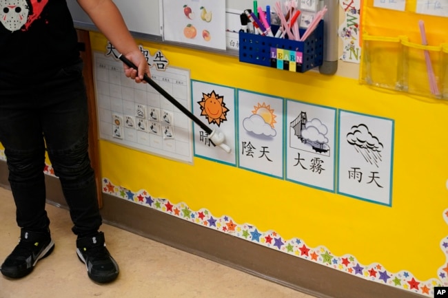 n Suzy Tom's first grade class a student points at pictures and characters on a wall at the Alice Fong Yu school in San Francisco, Tuesday, Aug. 30, 2022. (AP Photo/Eric Risberg)