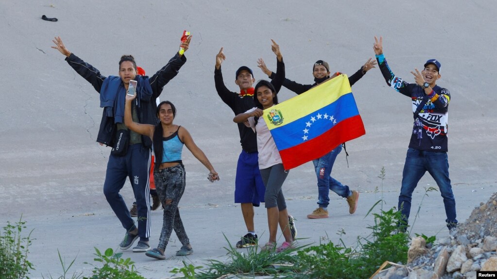 Migrantes venezolanos que buscan asilo reaccionan tras cruzar el río Bravo para entregarse a los agentes de la Patrulla Fronteriza de EEUU en El Paso, Texas, EEUU, visto desde Ciudad Juárez, México, el 23 de septiembre de 2022.