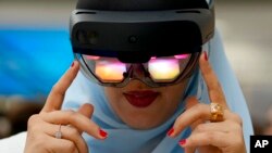VR virtual reality နည်းပညာသုံးနားကြပ်ကို သုံးကြည့်နေတဲ့ အာရပ်စော်ဘွားများပြည်ထောင်စု၊ ဒူဘိုင်းမြို့ အမျိုးသမီးတဦး။