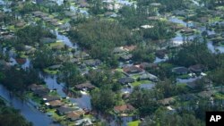 Homes are surrounded by flood waters caused by Hurricane Ian, Thursday, Sept. 29, 2022, in Fort Myers, Fla. Climate change added at least 10 percent more rain to Hurricane Ian, a study prepared immediately after the storm shows. (AP Photo/Marta Lavandier)