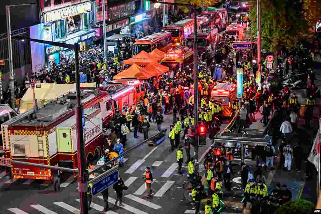 Onlookers, police and paramedics gather where dozens of people suffered cardiac arrest, in the popular nightlife district of Itaewon in Seoul on Oct. 30, 2022. 