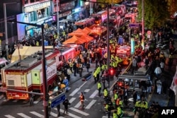 Penonton, polisi dan paramedis berkumpul di mana puluhan orang menderita serangan jantung, di distrik kehidupan malam Itaewon yang populer di Seoul pada 30 Oktober 2022. (Foto: AFP)