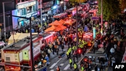 Penonton, polisi dan paramedis berkumpul di mana puluhan orang menderita serangan jantung, di distrik kehidupan malam populer Itaewon di Seoul, 30 Oktober 2022.