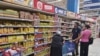 Tunisians looking at food prices while shopping at a local supermarket, Tunis, October 10, 2022