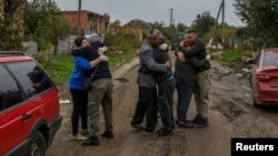 乌克兰哈尔科夫地区村民返回已经解放的家乡后与邻居们拥抱。（2022年10月2日）