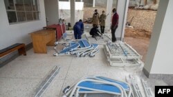 FILE - Ugandan Medical staff members assemble beds to be used in the Ebola treatment Isolation Unit at Mubende regional referral hospital in Uganda on Sept. 24, 2022.