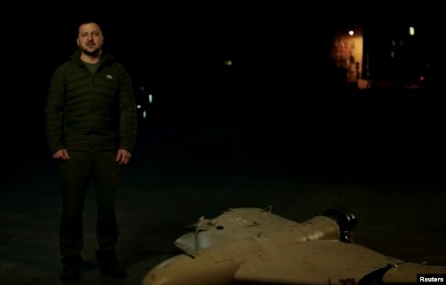 In a screengrab from video released by Ukraine's Presidential Press Service Oct. 27, 2022, President Volodymyr Zelenskyy is seen speaking next what appears to be the wreckage of a downed drone.