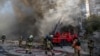 FILE - Firefighters help a woman evacuate from a residential building destroyed by a Russian drone strike, in Kyiv, Ukraine, Oct. 17, 2022. Local authorities said the weapon used was an Iranian-made Shahed-136.