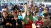 FILE - Children stand behind a fence in a hangar as they wait for their departure at the Ramstein US Air Base in Ramstein, Germany, Aug. 30, 2021. 
