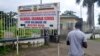 FILE - A man walks past the entrance of a bilingual school in Buea, the capital of the Southwest Region of Cameroon, Sept. 24, 2019