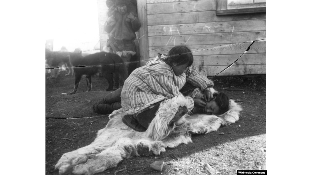 A Siberian Yupik woman skin stitching the face of a young woman, c. 1900. Photo by Russian ethnographer Vladimir Bogoras.