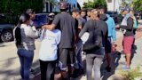 FILE - Immigrants gather in Martha's Vineyard, Massachusetts, Sept. 15, 2022. Florida Governor Ron DeSantis last year arranged to transport migrants to the area as part of an effort by Texas and Florida Republican leaders to send some immigrants to Democratic-run cities.