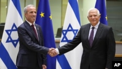 Kepala Kebijakan Luar Negeri Uni Eropa Josep Borrell (kanan) berjabat tangan dengan Menteri Intelijen Israel Elazar Stern sebelum pertemuan di gedung Dewan Uni Eropa di Brussel hari Senin, 3 Oktober 2022. 