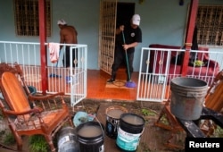 A man cleans his home from mud originating from the overflow of the river after Hurricane Julia hit the town and dumped heavy rains in La Cruz, Nicaragua, Oct. 10, 2022.