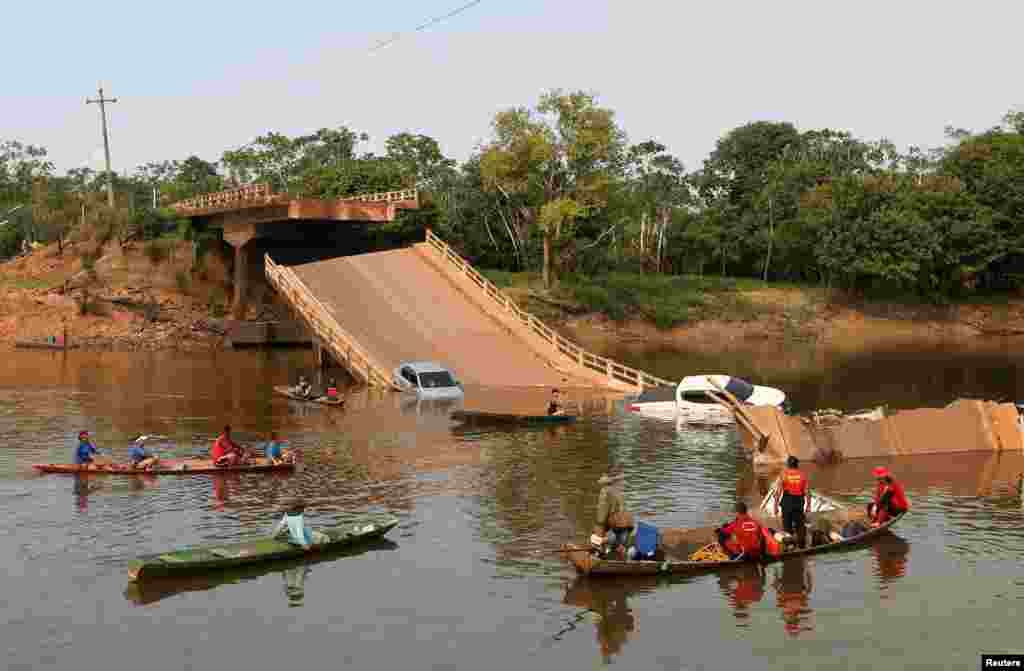 Penduduk setempat dan petugas penyelamat menginspeksi dengan perahu di sungai Curuca setelah sebuah jembatan runtuh di Careiro da Varzea, dekat Manaus, Brazil. (Reuters)