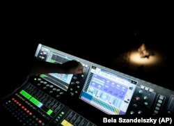 A technician sets up the lighting of the stage of the Trafo House of Contemporary Arts in Budapest, Hungary, Sept. 19, 2022. (AP Photo/Bela Szandelszky)