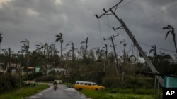 Des poteaux électriques basculent après avoir été happés par l'ouragan Ian à Pinar del Rio, à Cuba, le 27 septembre 2022.