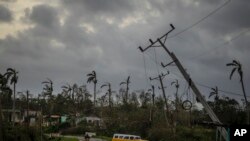 Beberapa tiang listrik tampak bengkok setelah Badai Ian menerjang wilayah Pinar del Rio, di Kuba, pada 27 September 2022. (Foto: AP/Ramon Espinosa)