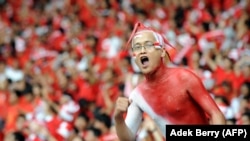 Suporter Indonesia meneriakkan yel-yel menjelang final kedua AFF Suzuki Cup 2010 di Jakarta pada 29 Desember 2010. Malaysia keluar sebagai juara AFF Suzuki Cup 2010. (Foto: AFP/Adek Berry)