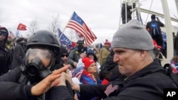 FILE - In this Jan. 6, 2021, image from video, Alan Byerly, right, is seen attacking an Associated Press photographer during a riot at the U.S. Capitol in Washington. 