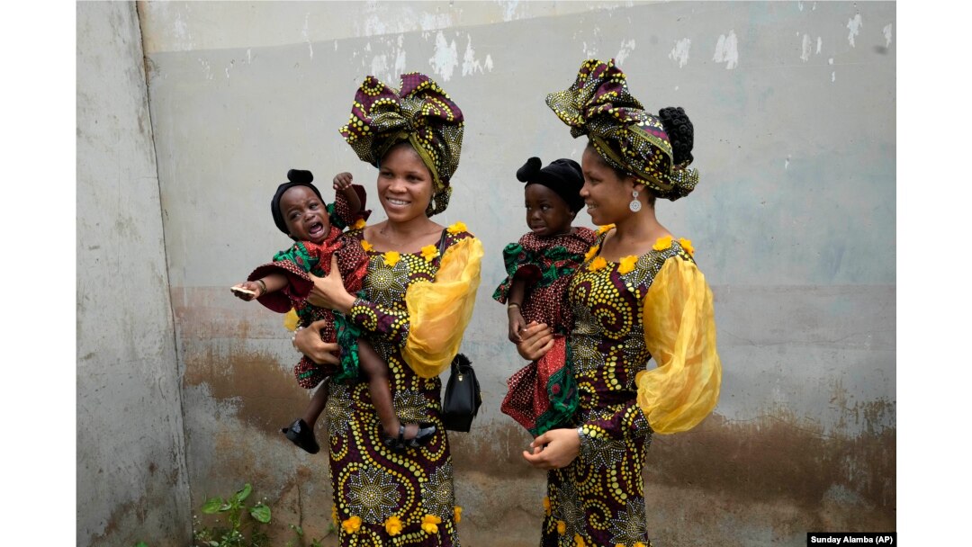 Saudara kembar Oladapo Taiwo, kiri, dan Oladapo Kehinde, 21, sedang menggendong dalam festival kembar tahunan di Igbo-Ora Nigeria barat daya, Sabtu, 8 Oktober 2022. (Foto: AP/Minggu Alamba)