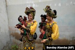 Saudara kembar Oladapo Taiwo, kiri, dan Oladapo Kehinde, 21, sedang menggendong dalam festival kembar tahunan di Igbo-Ora Nigeria barat daya, Sabtu, 8 Oktober 2022. (Foto: AP/Minggu Alamba)