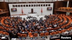 FILE - Turkey's main opposition Republican People's Party (CHP) lawmakers hold placards as they protest a contentious media bill, at the Turkish parliament in Ankara, Turkey, Oct. 4, 2022.