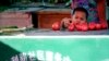 FILE - A Uyghur child plays with tomato at a street vender in Urumqi, western China's Xinjiang province, July 11, 2009. 