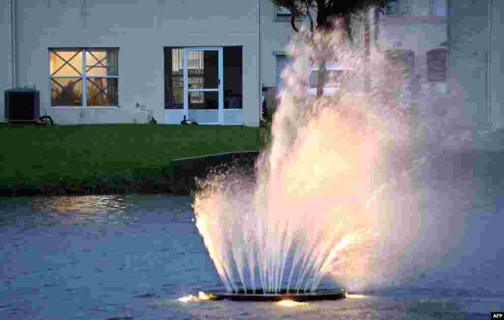 A fountain inside a condominium complex blows almost horizontal as residents tape their windows for security, south of Orlando, Florida, on Sept. 28, 2022.