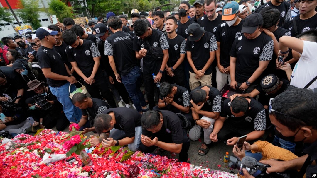 Para pemain dan ofisial klub sepak bola Arema FC berdoa di luar Stadion Kanjuruhan, Malang, yang menyebabkan banyak suporter kehilangan nyawa akibat terinjak-injak pada 3 Oktober 2022. (Foto: AP)