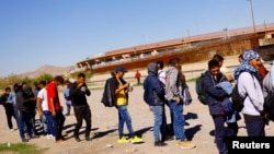 Migrantes esperan recibir comida cerca del puente Paso del Norte en Ciudad Juárez, México, el 20 de octubre de 2022.