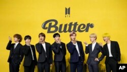 FILE- Members of South Korean K-pop band BTS, V, SUGA, JIN, Jung Kook, RM, Jimin, and j-hope from left to right, pose for photographers ahead of a press conference to introduce their new single "Butter" in Seoul, South Korea, May 21, 2021.