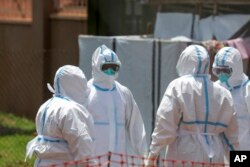 Para dokter berdoa sebelum memasuki bagian isolasi Ebola Rumah Sakit Rujukan Regional Mubende, di Mubende, Uganda, 29 September 2022. Ebola menjadi salah satu virus yang mematikan dan menelan banyak korban di Uganda. (Foto: AP)