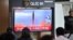 FILE - People sit in front of a television screen showing a news broadcast with file footage of a North Korean missile launch, at a railway station in Seoul, South Korea, Oct. 6, 2022.