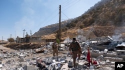 Members of exiled Komala Party inspect aftermath of bombing in the village of Zrgoiz, near Sulaimaniyah, Iraq, where the bases of several Iranian opposition groups are located, Sept. 28, 2022.