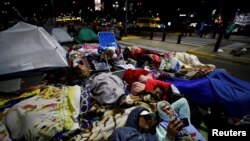 Anggota dari sejumlah organisasi sosial bermalam di luar Kantor Kementerian Pembangunan Sosial di Buenos Aires, Argentina, pada 27 September 2022. Mereka memprotes inflasi yang tinggi serta banyaknya pengangguran yang tercipta di negara tersebut. (Foto: Reuters/Agustin Marcarian)