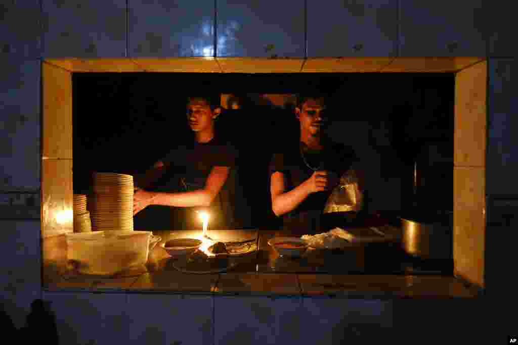 Staff at an eatery work by candlelight after a failure in Bangladesh's national power grid plunged much of the country into a blackout in Dhaka, Bangladesh.