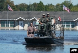 Osceola County sheriff's department workers use a fanboat as they urge residents to leave a flooded area following Hurricane Ian on Sept. 30, 2022, in Kissimmee, Fla.