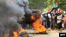 FILE: Sudanese protesters block a street in Omdourman the capital Khartoum's twin city on October 21, 2022. - Thousands of Sudanese took to the streets to renew protests nearly a year after a military coup derailed the country's transition to democracy.