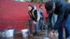 Personas llenan contenedores con agua de las bombas de agua públicas, el lunes 31 de octubre de 2022, en Kiev. (AP Foto/Sam Mednick)